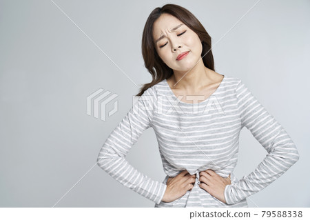 abdominal pain, menstruation, menstrual cramps, pain, young woman, nukki, gray background abdominal pain, menstruation, menstrual cramps, pain, young woman, nukki, gray background 79588338
