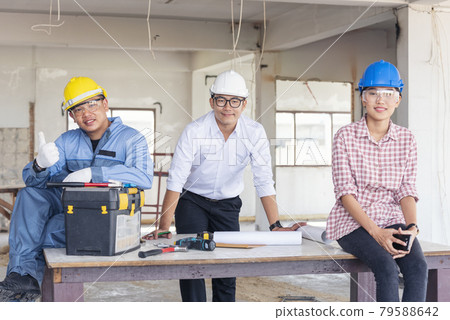 Construction engineer teamwork Safety Suit Trust Team Holding White Yellow Safety hard hat Security Equipment on Construction Site. Hardhat Protect Head for Civil Construction Engineer Concept 79588642
