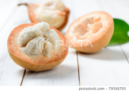 Half Santol on wood background, 79588705