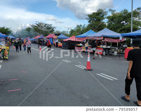 SEREMBAN, MALAYSIA -MARCH 7, 2020: Street vendors and hawkers sell local goods and food to the public on-street by opened a small stall. . They called the passersby to stop by their booth. SEREMBAN, MALAYSIA -MARCH 7, 2020: Street vendors and hawkers sell local goods and food to the public on-street by opened a small stall. . They called the passersby to stop by their booth. 79589857