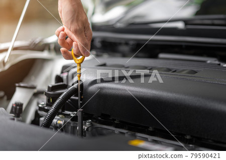 Close up of hands checking the oil level in the engine before a trip or journey, Car check condition concept. Close up of hands checking the oil level in the engine before a trip or journey, Car check condition concept. 79590421