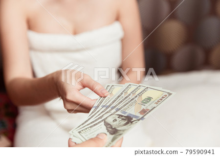 Women night worker reciving money from customer pay for personal massage service in hotel room. 79590941
