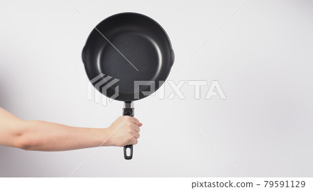 Pan cleaning. Man hand on white background cleaning the non stick pan with handy dish washing sponge which yellow color on the soft side and green on hard side for hygiene after cook. Electric pan. Pan cleaning. Man hand on white background cleaning the non stick pan with handy dish washing sponge which yellow color on the soft side and green on hard side for hygiene after cook. Electric pan. 79591129