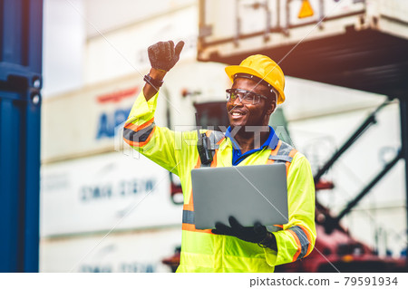 Black African happy worker working in logistic shipping with laptop computer control loading containers at port cargo. Import export shipping industry people. Black African happy worker working in logistic shipping with laptop computer control loading containers at port cargo. Import export shipping industry people. 79591934