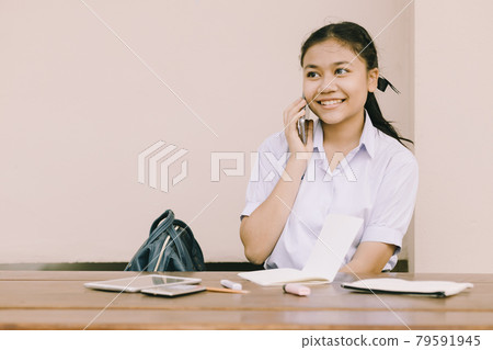 Asian Thai cute girl teen student school uniform using phone calling happy smile. Asian Thai cute girl teen student school uniform using phone calling happy smile. 79591945