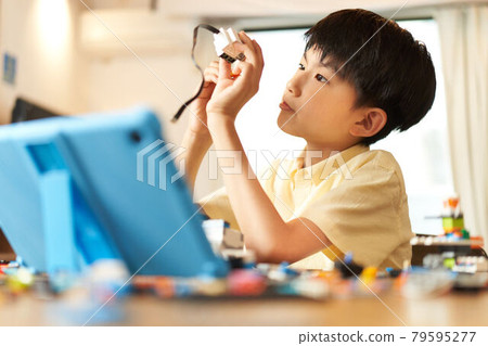 Boy assembling programming materials Boy assembling programming materials 79595277
