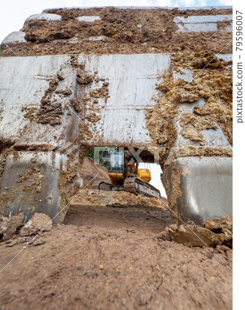 Cracked earth under excavator bucket bite the ground. Cracked earth under excavator bucket bite the ground. 79596007