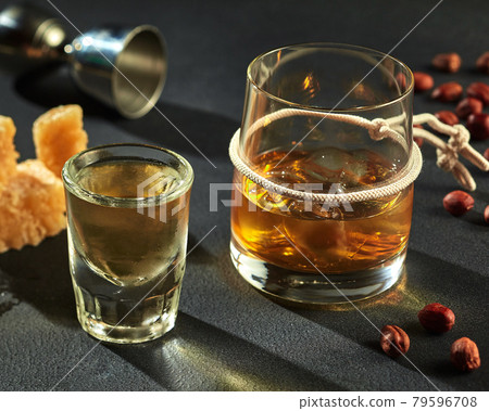 Shot of cold tequila and goblet of whiskey with ice 79596708