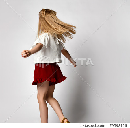 Unrecognizable little blonde girl dances and 79598126