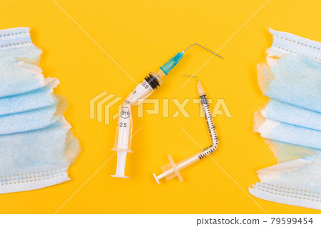 Broken Medical Syringe and Torn Medical Face Mask Broken Medical Syringe and Torn Medical Face Mask 79599454