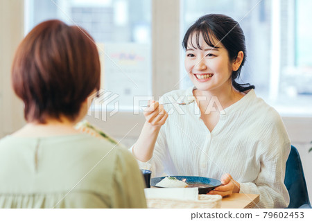 一個女人一邊吃午飯一邊和她的女朋友聊天 79602453