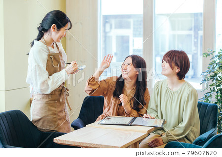 選擇菜單的顧客和咖啡館工作人員 選擇菜單的顧客和咖啡館工作人員 79607620