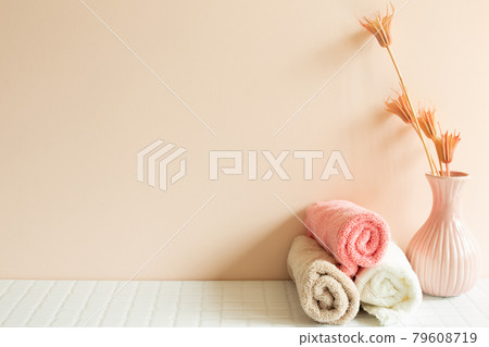 Bathroom towel, vase of plant on white mosaic tile table. pink wall background. Skin care and spa concept. Home interior Bathroom towel, vase of plant on white mosaic tile table. pink wall background. Skin care and spa concept. Home interior 79608719