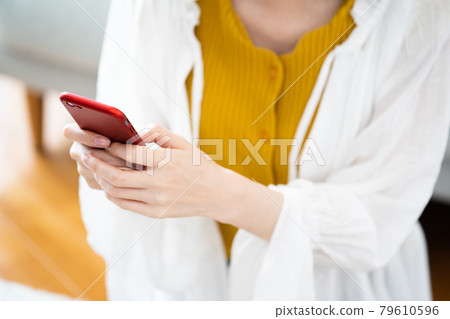 Young woman looking at a smartphone Young woman looking at a smartphone 79610596