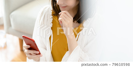 Young woman looking at a smartphone Young woman looking at a smartphone 79610598