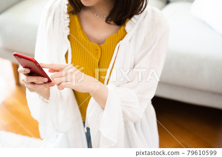 Young woman looking at a smartphone Young woman looking at a smartphone 79610599