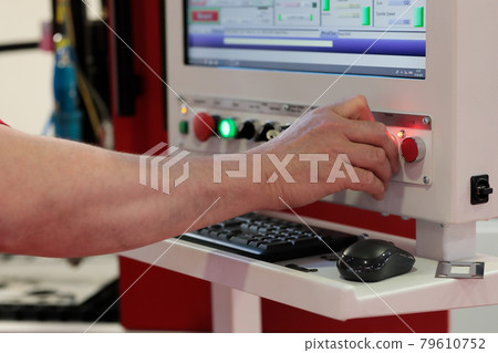 operator controls CNC laser cutting machine 79610752