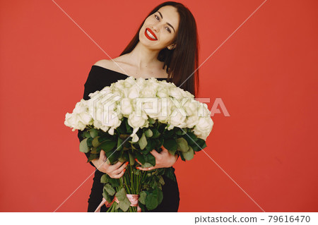 Woman in a black dress with bouquet of roses 79616470