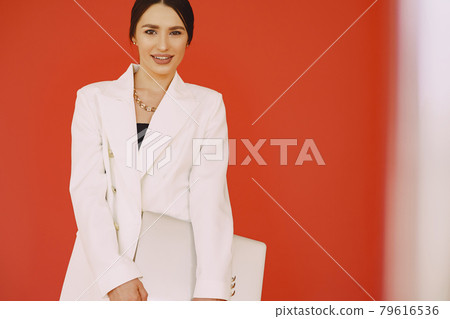 Woman standing on a red background Woman standing on a red background 79616536