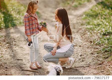 Mother with daughter in a spring forest with dog Mother with daughter in a spring forest with dog 79617177