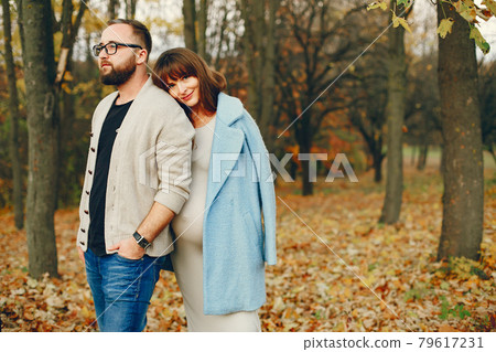 Elegant couple spend time in a autumn park Elegant couple spend time in a autumn park 79617231