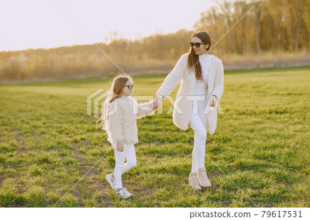Elegant mother with daughter in a summer forest Elegant mother with daughter in a summer forest 79617531