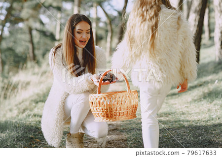 Elegant mother with daughter in a summer forest Elegant mother with daughter in a summer forest 79617633
