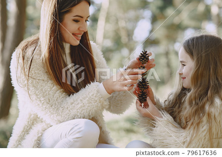 Elegant mother with daughter in a summer forest Elegant mother with daughter in a summer forest 79617636