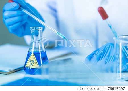 Hand of doctor or researcher in medical blue gloves holding test tube and drop the water for analyzing work. 79617697