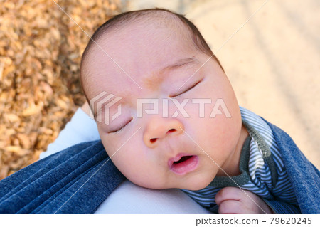 A lovely baby sleeping in his mother's arms A lovely baby sleeping in his mother's arms 79620245