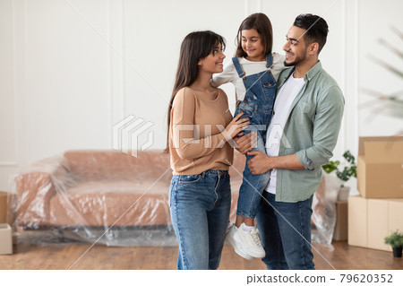Happy family looking at each other, posing in new flat Happy family looking at each other, posing in new flat 79620352