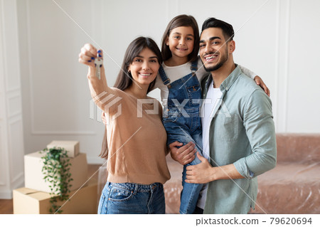 Happy young family showing keys of their apartment Happy young family showing keys of their apartment 79620694