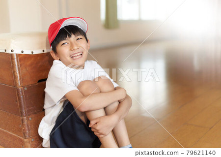 一個男孩靠在一個跳馬箱上坐著 79621140
