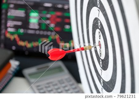 Darts with dart in center against the background of laptop with analytics for cryptocurrency financial market analysis and trade data index chart 79621231