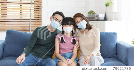 Happy Asian family wearing a mask to protect against viruses at home living room. Happy Asian family wearing a mask to protect against viruses at home living room. 79621789