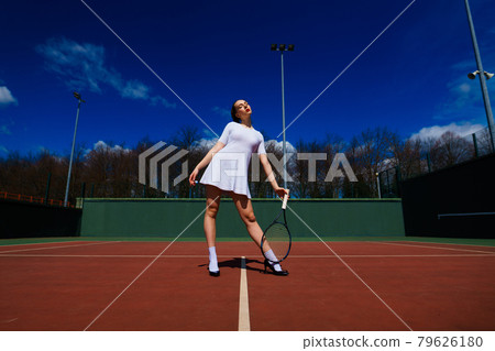 Sexy girl tennis player holding tennis racket on the court. Young woman is playing tennis. 79626180