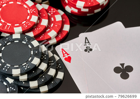 Casino chips and playing cards on dark reflective background Casino chips and playing cards on dark reflective background 79626699