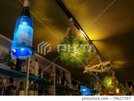 Wine bottle lights and green ball lights on the ceiling of a fashionable tropical bar 79627167