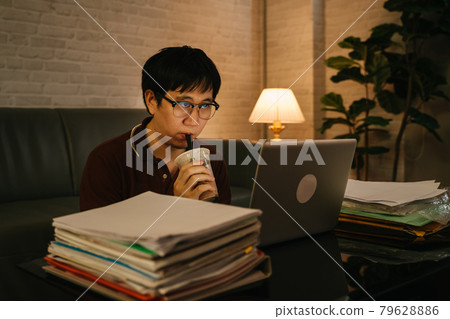 Man working late till night and drinking coffee Man working late till night and drinking coffee 79628886