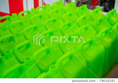 Many empty green plastic jerrycans 79630285