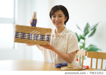 一個拿著用工藝帶製作的籃子的女人 79631852
