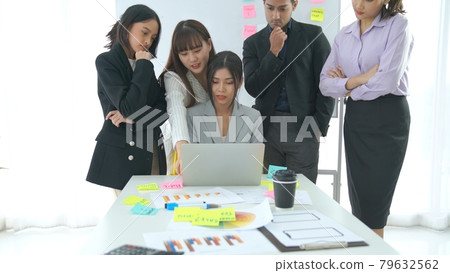 Business people proficiently discuss work project on computer 79632562