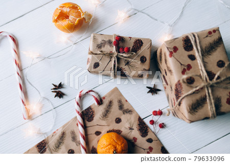 Christmas gifts, lollipop, tangerine on white wooden background Christmas gifts, lollipop, tangerine on white wooden background 79633096