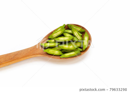 Fruit of broken bone tree slices in wooden spoon on white background. Fruit of broken bone tree slices in wooden spoon on white background. 79633298