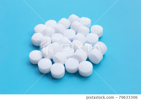 Naphthalene mothballs on blue backgrond. Naphthalene mothballs on blue backgrond. 79633306