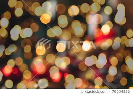 Red christmas decorations on the table at blurred christmas tree with candles Red christmas decorations on the table at blurred christmas tree with candles 79634322