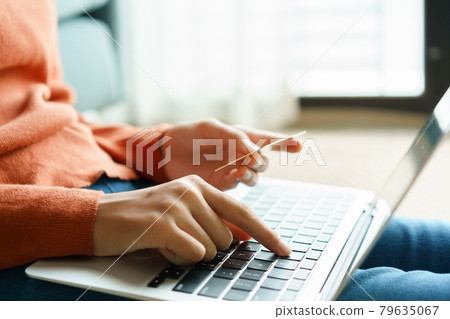 Hand of young woman are buying online with a credit card. Women are using laptop computer Hand of young woman are buying online with a credit card. Women are using laptop computer 79635067