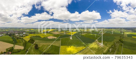 Panoramic aerial view over giant wind power field in Germany during daytime 79635343