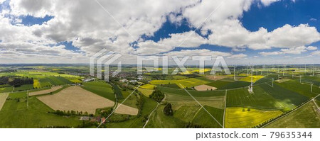 Panoramic aerial view over giant wind power field in Germany during daytime 79635344