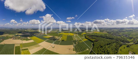 Panoramic aerial view over giant wind power field in Germany during daytime 79635346